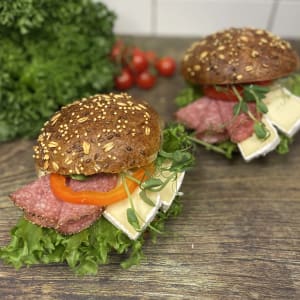 Två mörka frallor fyllda med salami, brieost samt grönsaker