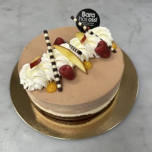 Choklad tårta med flera lager toppad med hallon och grädde, choklad tårta, tårta choklad
