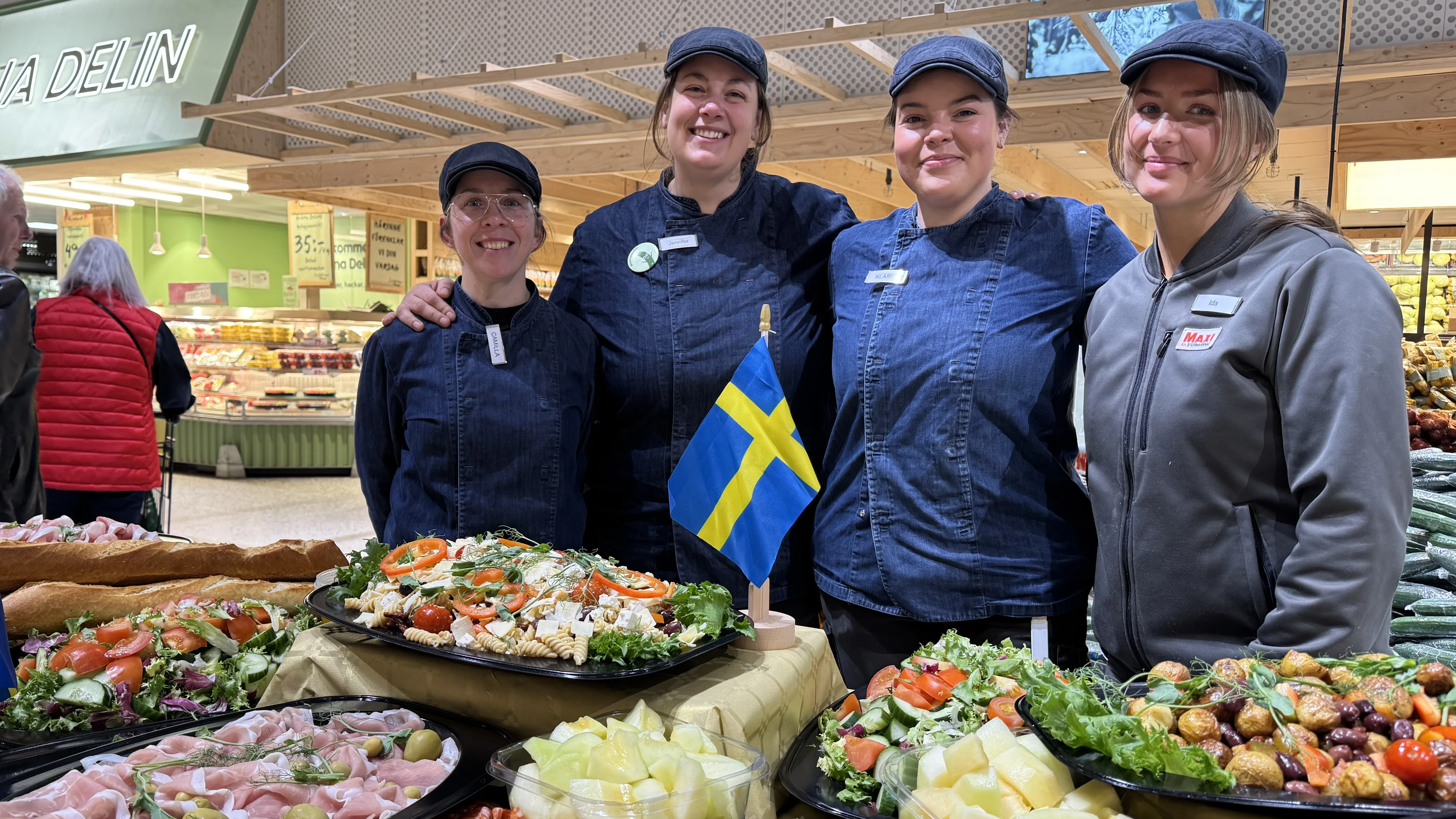 Personal som står och håller om varandra framför uppdukade bufféer