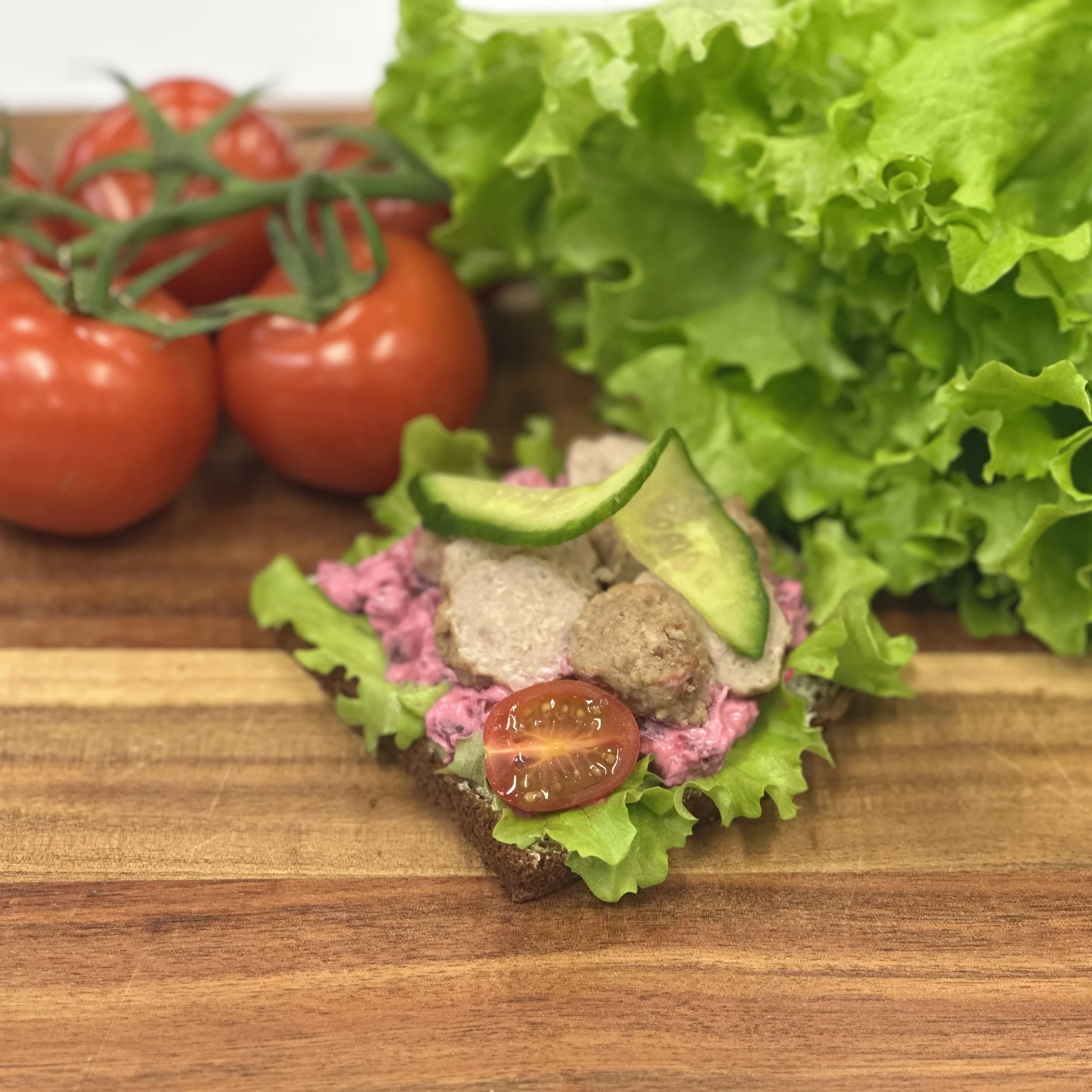 Smörrebröd med rödbetssallad, köttbullar, sallad, tomat och gurka.