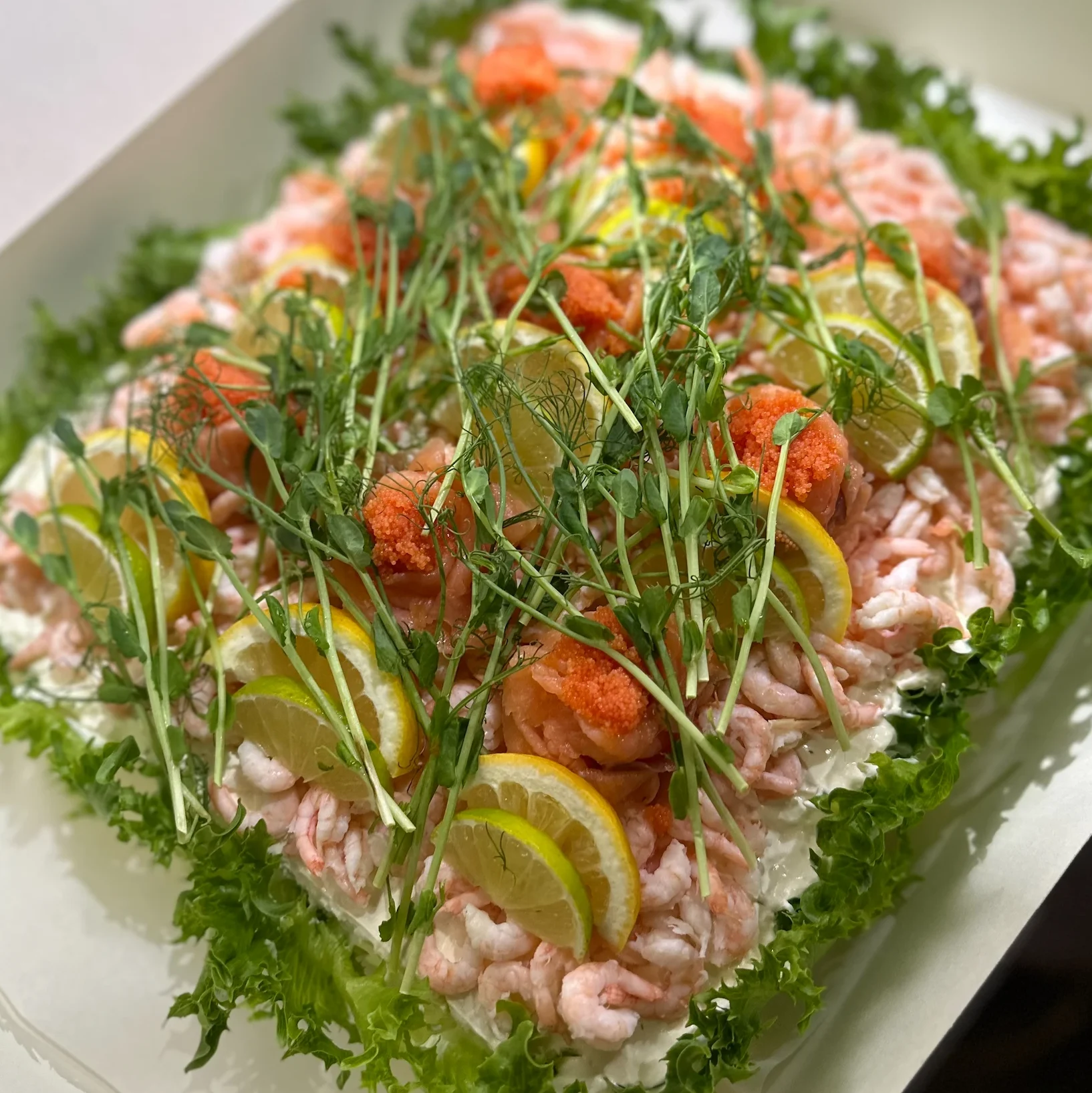 En klassisk smörgåstårta med skagenröra från vårt eget kök, toppad handskalade räkor & rökt lax