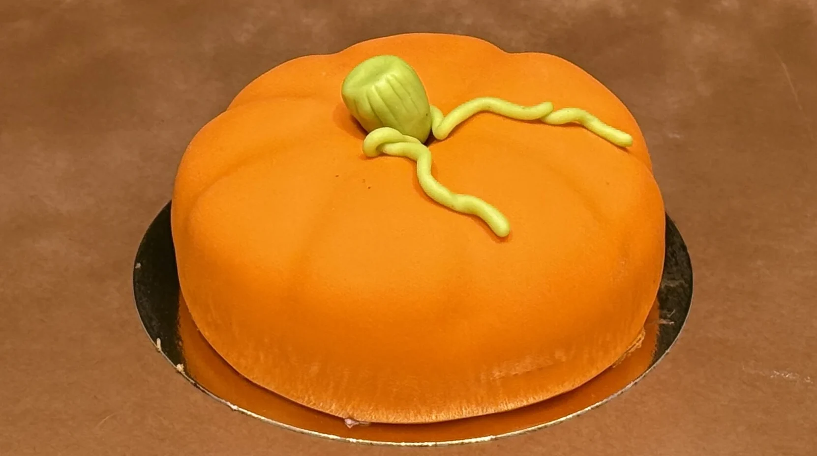 Prinsestårta täckt med orange marsipan som föreställer en pumpa.