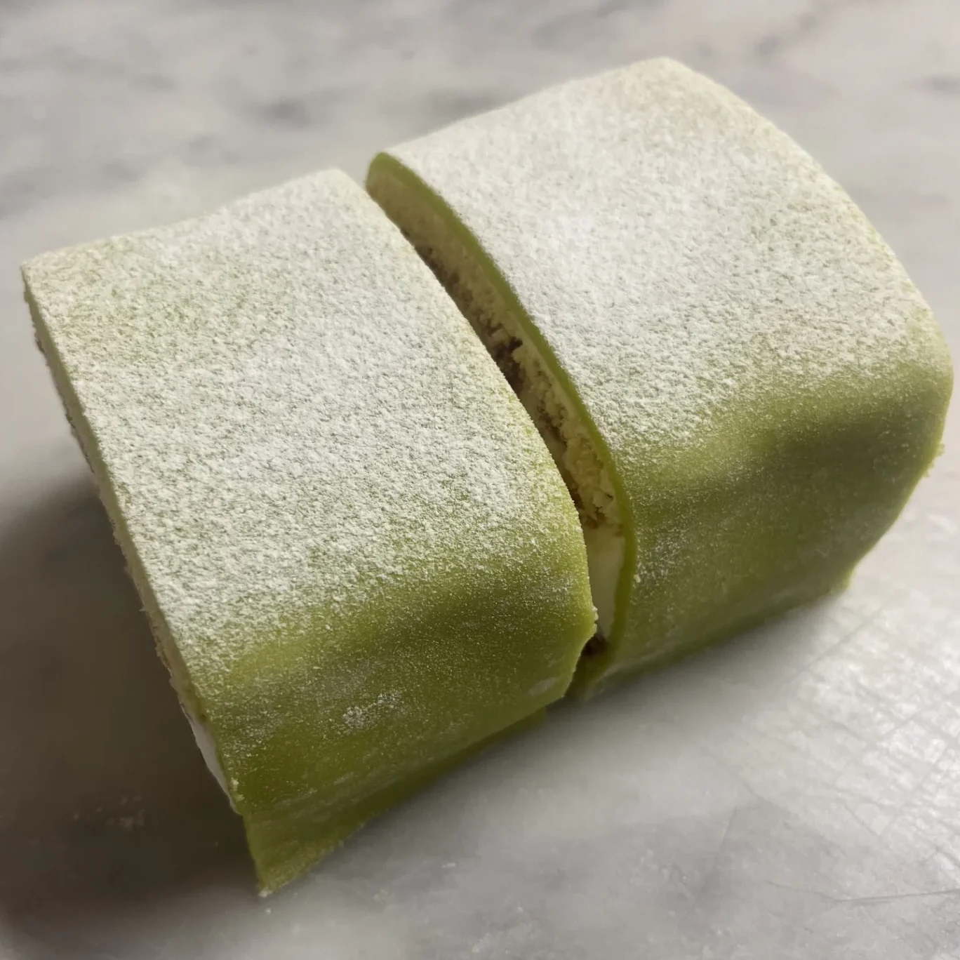 Gröna princessbakelser, fyllda med vaniljkräm, hallonsylt och grädde.