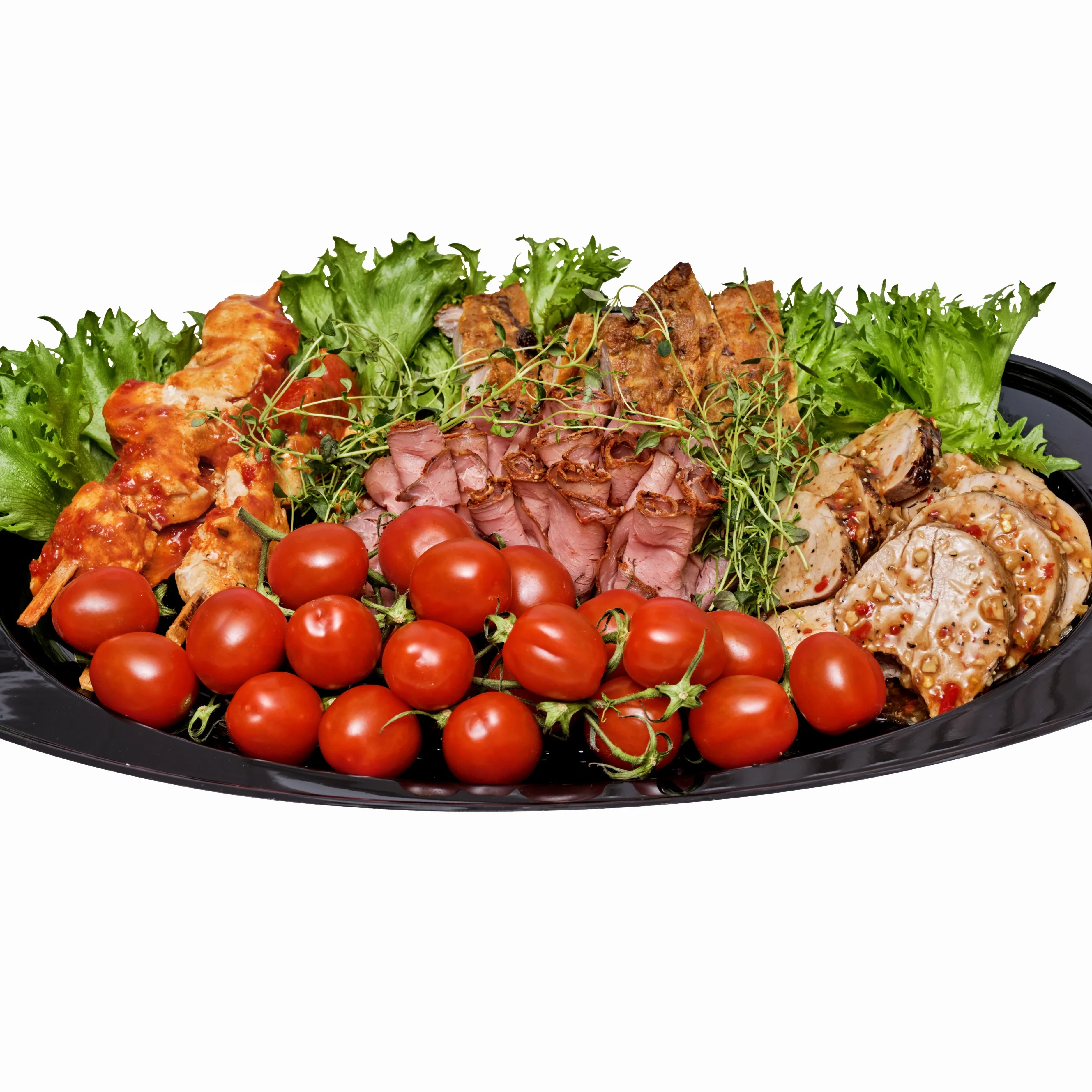 Ett grillmix fat med fem olika sorters kött och lite tomater och grönsallad för dekoration.