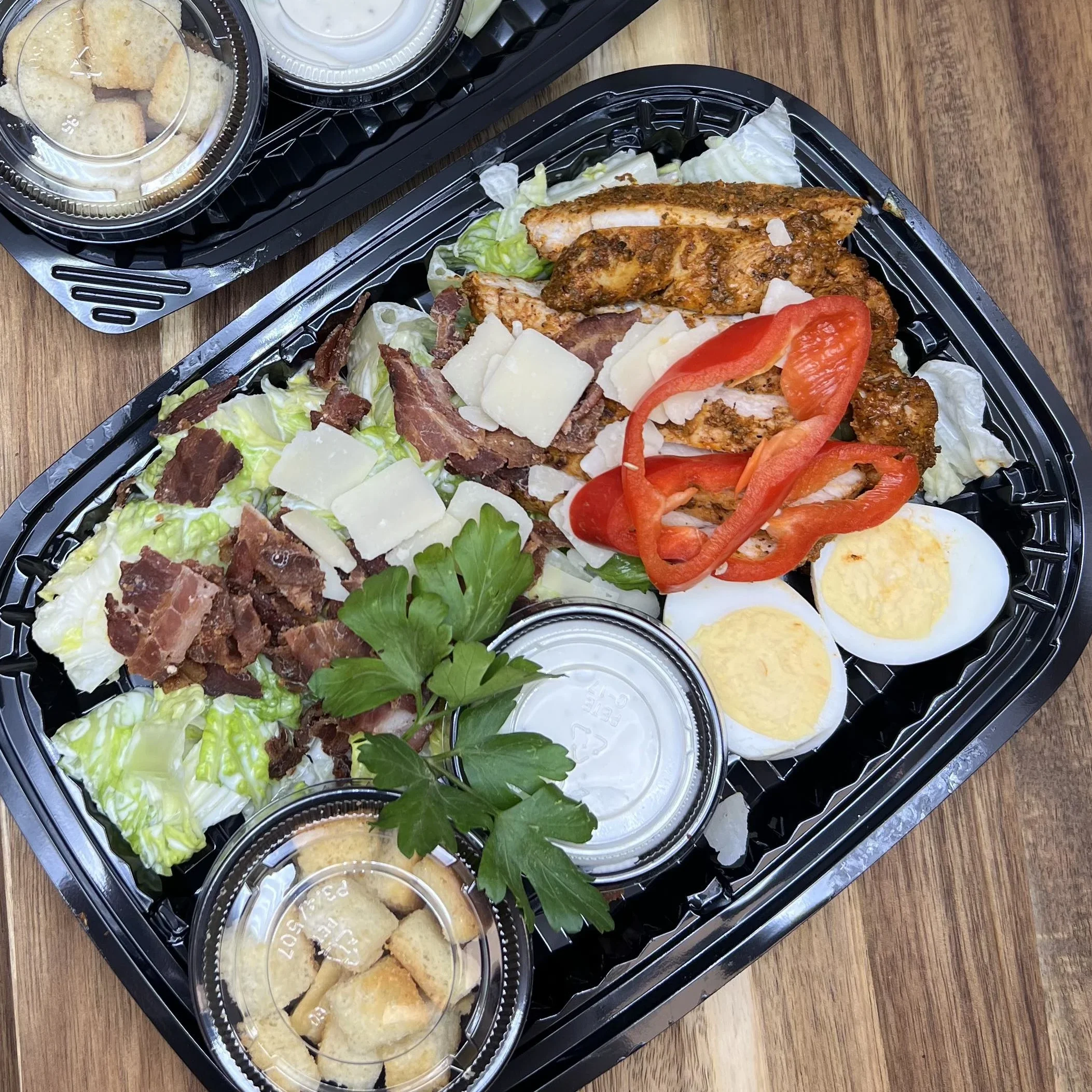Ceasarsallad sedd uppifrån. Den röda paprika sticker ut i bilden.