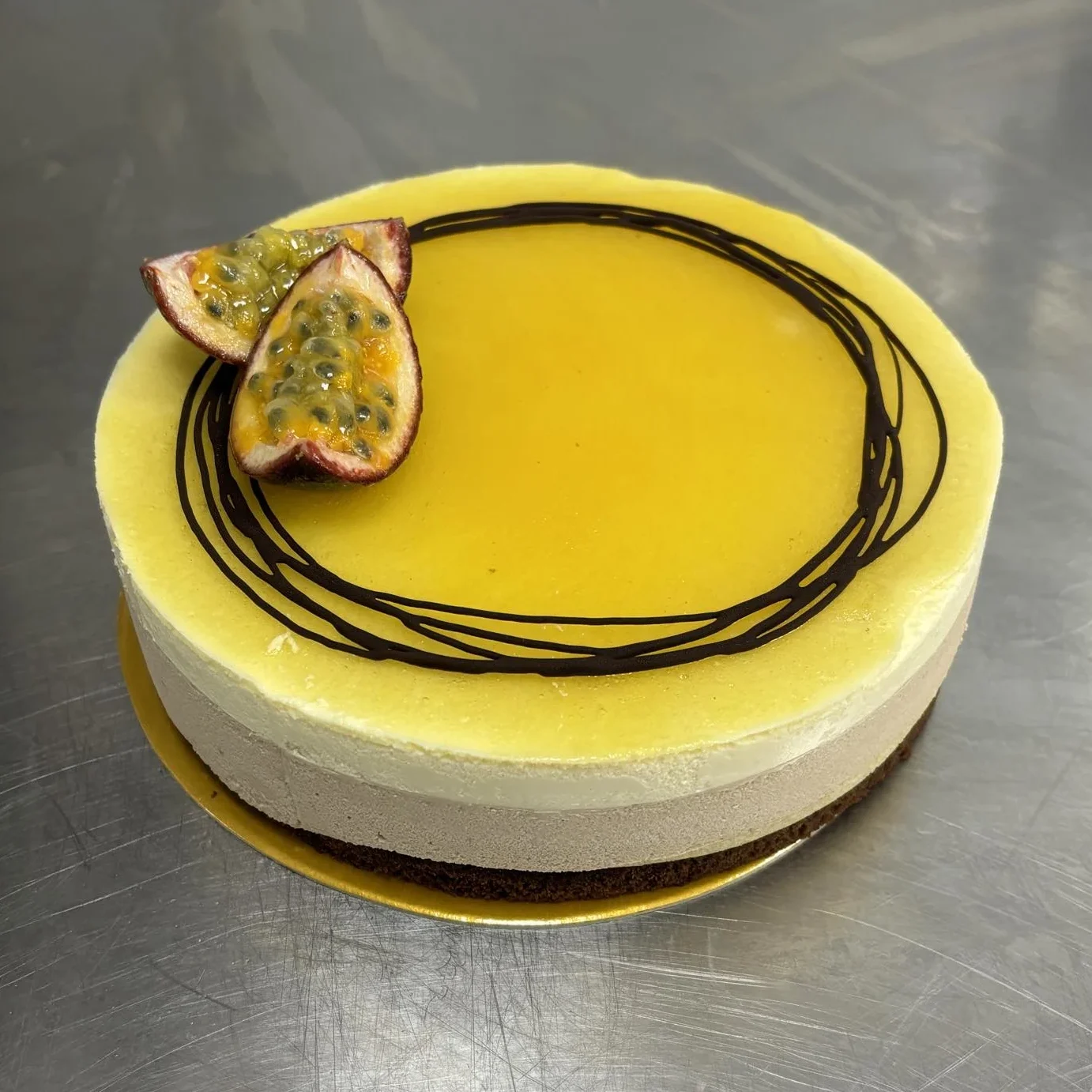 Spröd tårtbotten med ett lager av krispig hasselnötspraliné, mjölkchokladmousse, chokladtårtbotten och en friskt syrlig passionfruktsmousse. Toppad med passionsfruktgelé, choklad och färsk passionsfrukt.