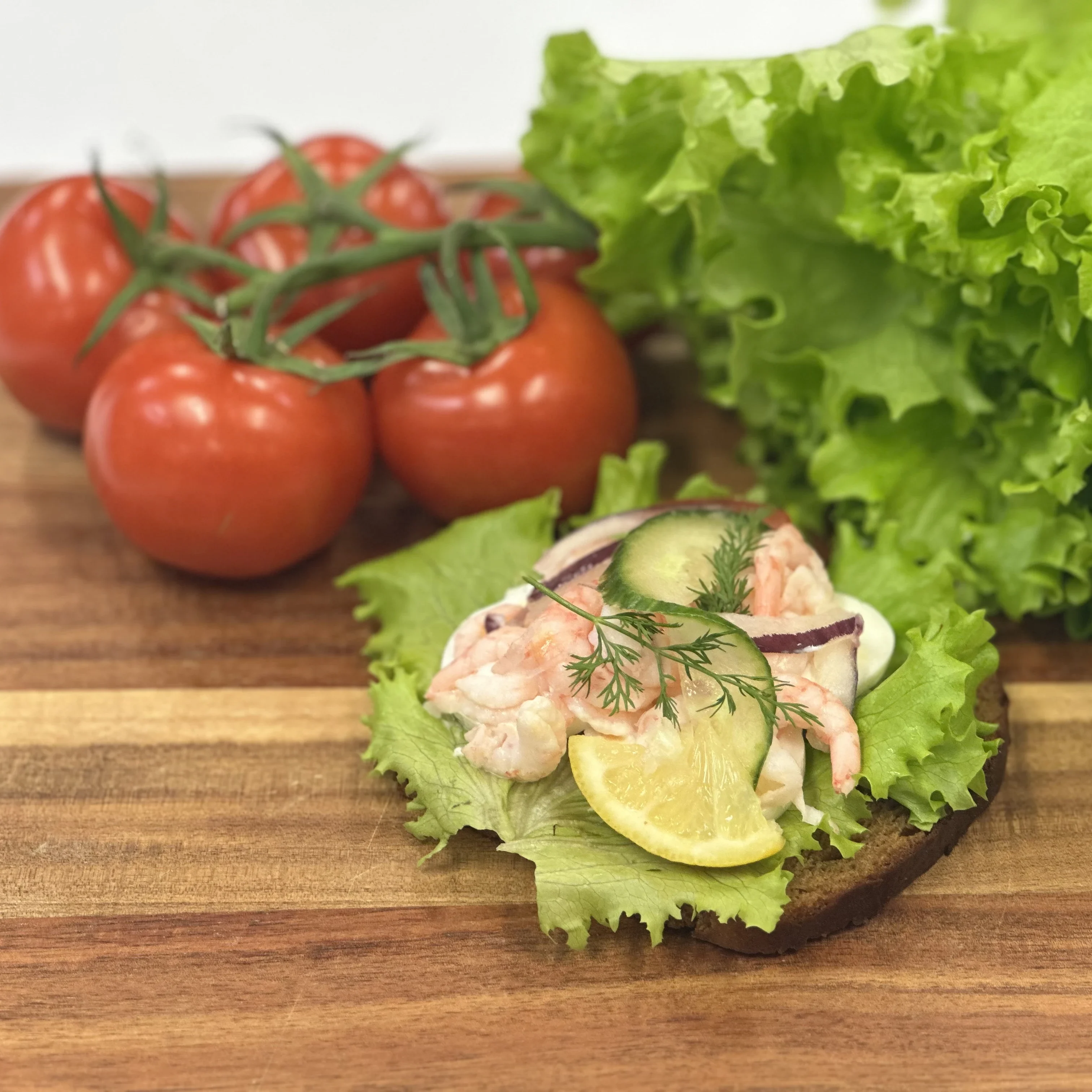 Smörrebröd med räkor, kokt ägg, sallad, tomat, gurka och dill.