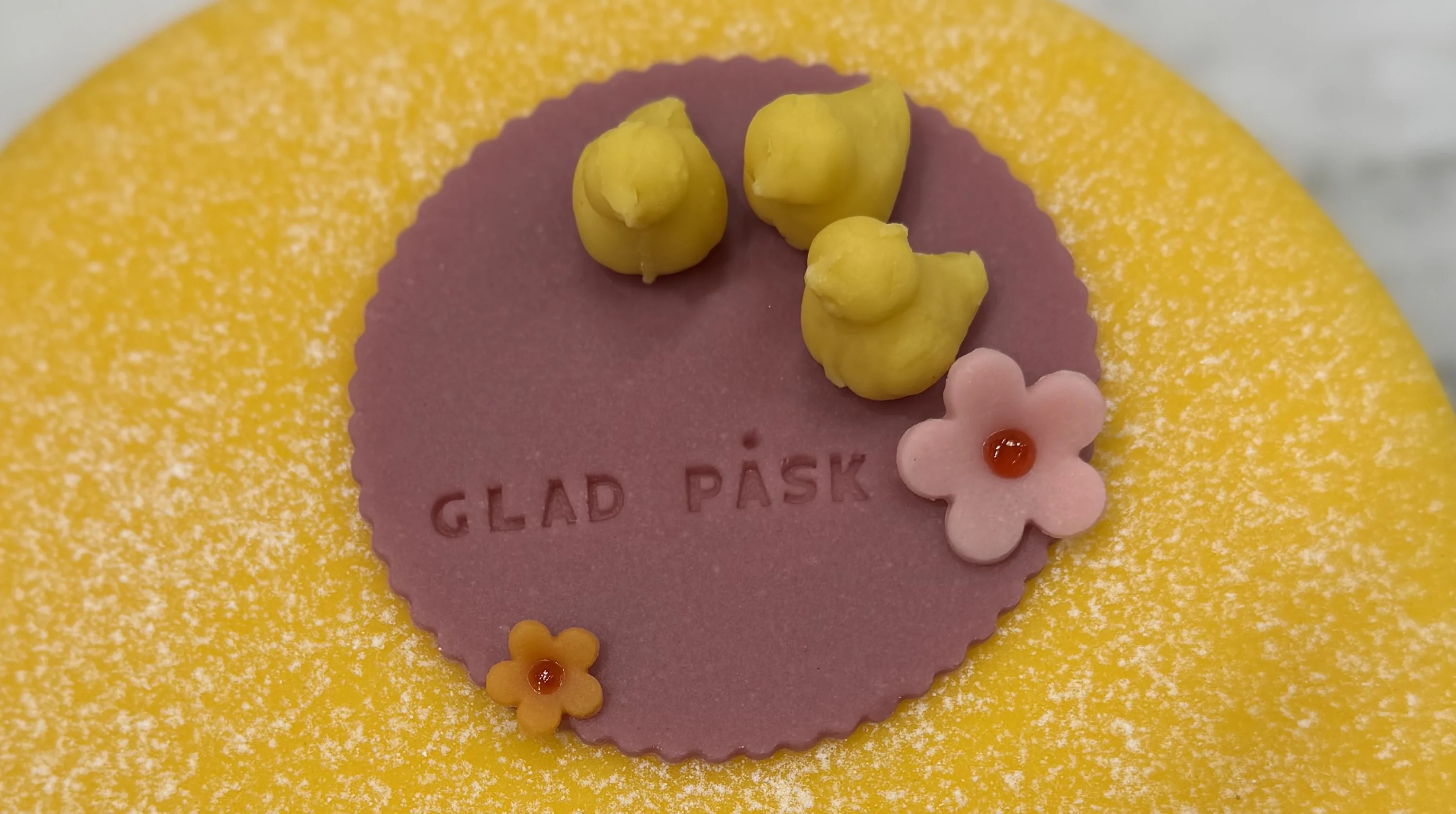 Inzoomad bild på den gula påsktårtan med gula marsipankycklingar