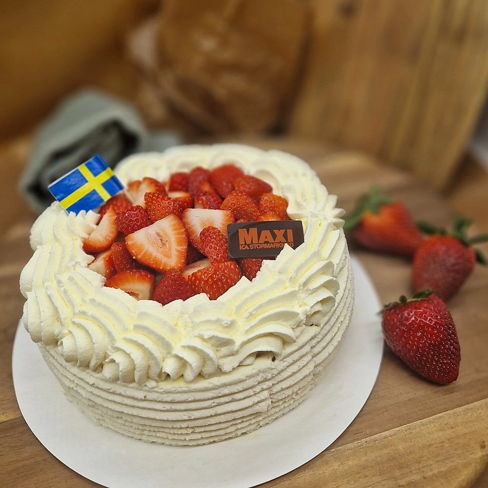 Jordgubbstårta med gräddrosetter och svensk flagga