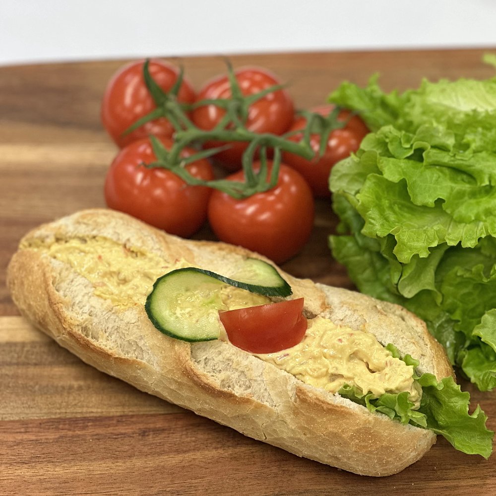 Nybakad baguette med kyckling och curry röra, sallad, tomat och gurka.