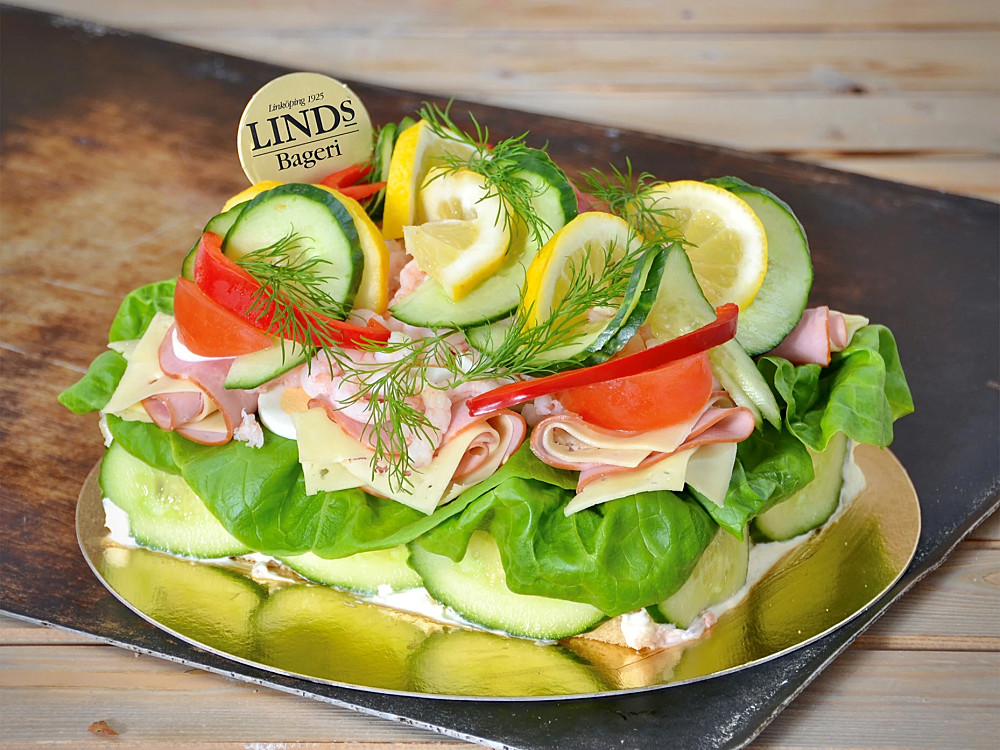 Fyllning av skinkröra och räksallad. Dekorerad med räkor, ägg, ost, skinka, sallad och grönsaker. Franskbottnar med vete och rågmjöl. (Innehåller: Gluten, laktos, fläsk, skaldjur, mjölk och ägg)