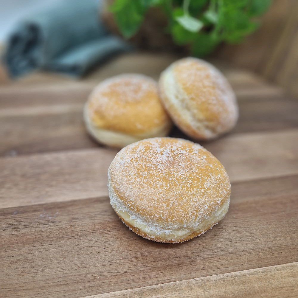 Vaniljmunk med strösocker på träbricka. Fika på fikabord