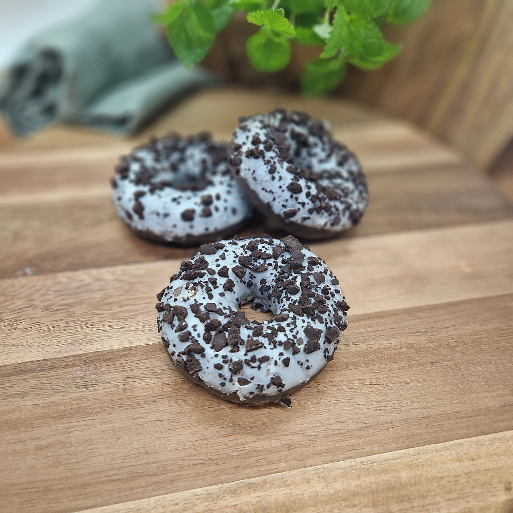 Donut cookies and cream på träbricka. Fika på fikabord