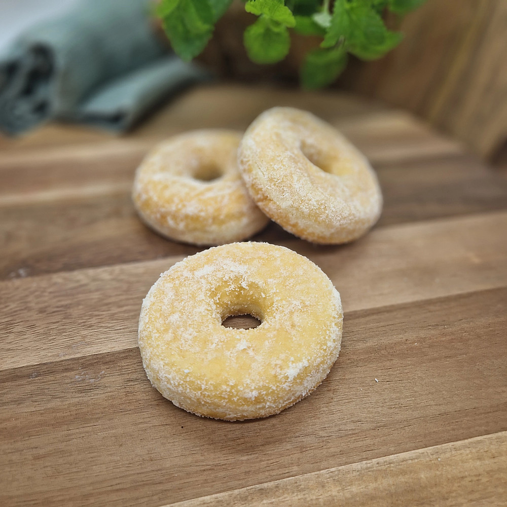 Donut med socker på träbricka. fika på fikabord