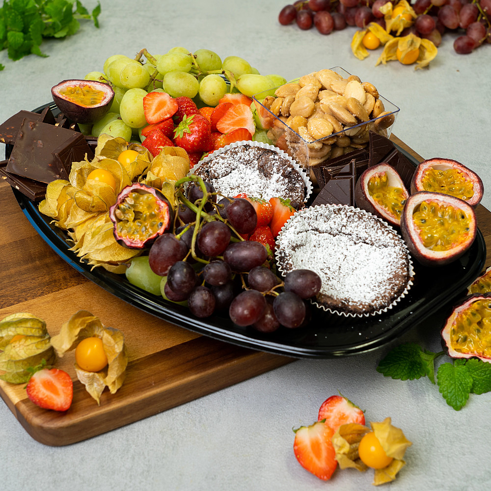 Ett dessertfat med choklad, mandlar, kladdkaka och färsk frukt