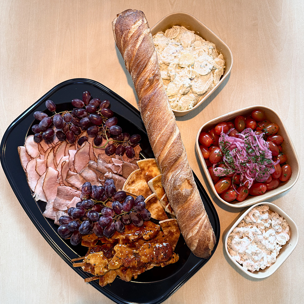 Liten buffé med Baguette, kycklingspett, tomatsallad, potatissallad, skagenröra, skinka uppskuret och upplagt med vindruvor