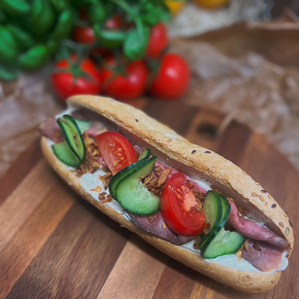 Baguette fylld med potatissallad, rostbiff, rostad lök och grönsaker