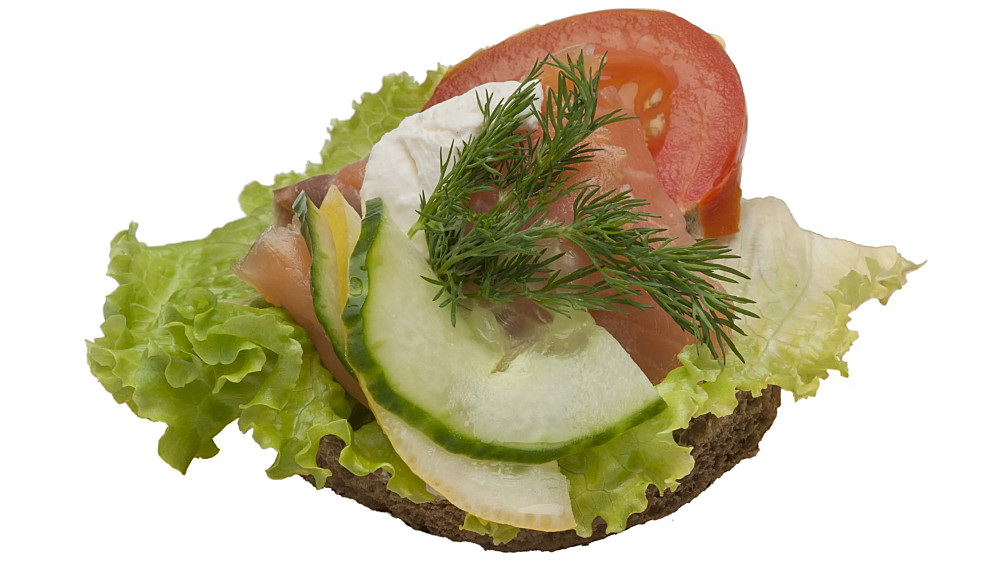 Smörrebröd på kavring. Garnerad med kallrökt lax, gurka och pepparrotskräm.