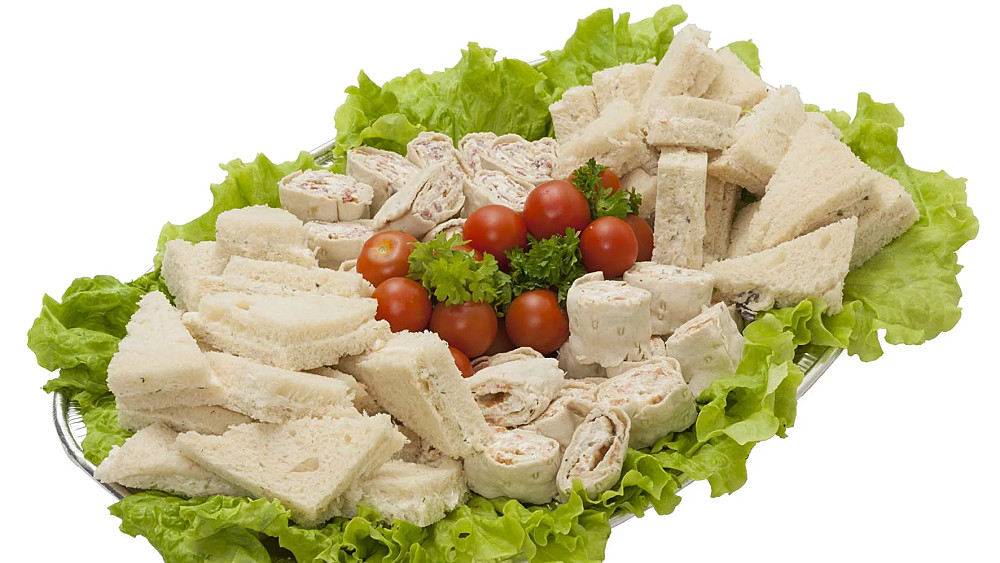 Smörgåssnittar upplagda på ett fat med sallad