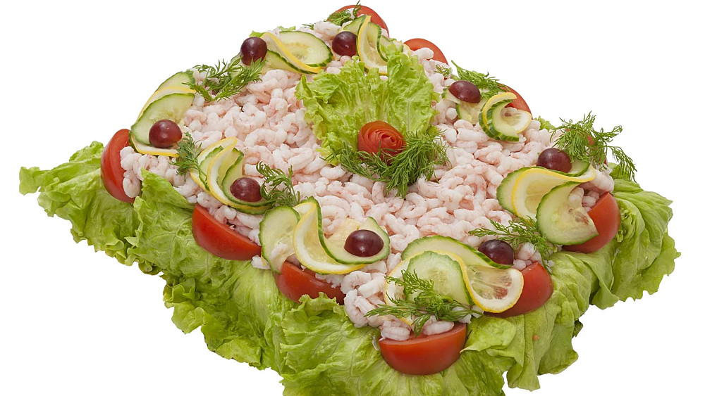 Smörgåstårta med räkfyllning. Garnerad med räkor och grönsaker.