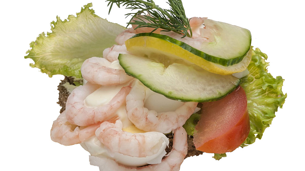 Smörrebröd på kavring. Toppad med räkor, ägg, majonnäs, dill och citron
