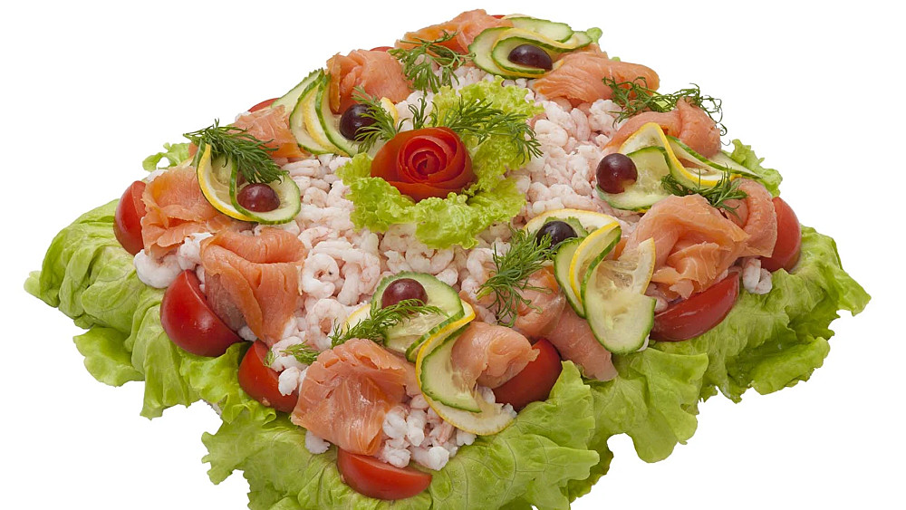 Smörgåstårta med räkfyllning. Garnerad med räkor, kallrökt lax och grönsaker.