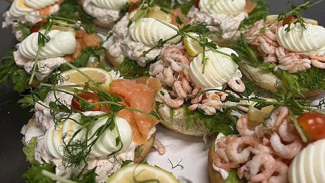 Smörgås med räkor ägg och pyntad med ärtskott