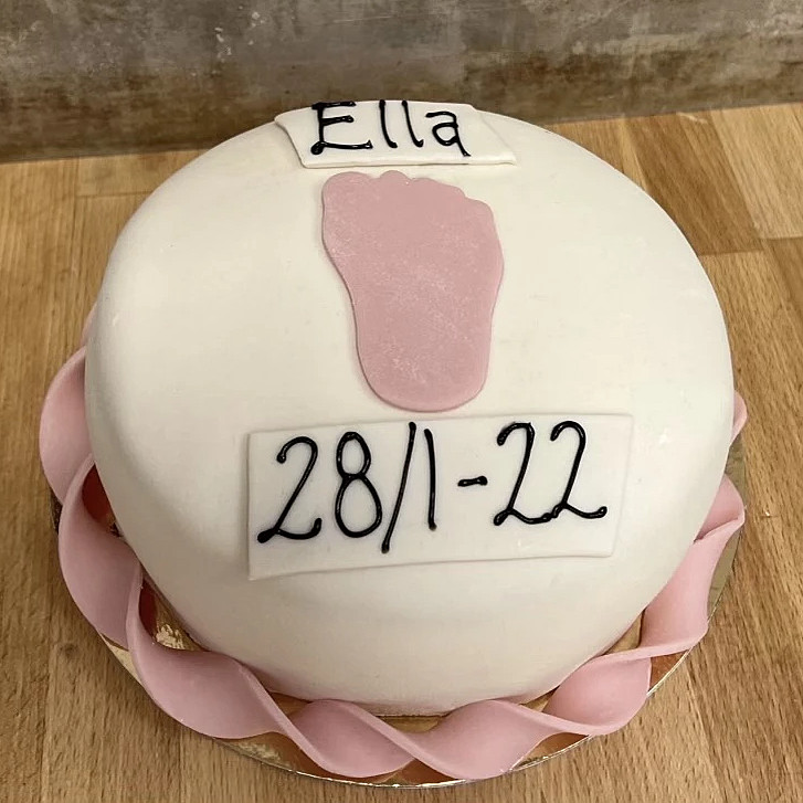 Tårta med rosa eller blå dekoration i marsipan med namn och datum