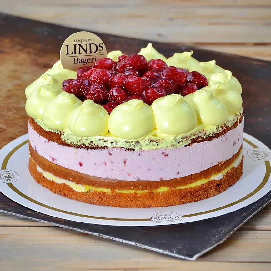 Sockerkaka, hallonmousse och citronkräm. Dekorerad med hallon i gelé.