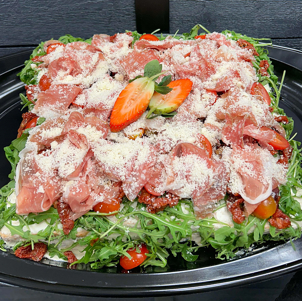 Italiensk smörgåstårta med fetsostkräm, skinkröra och kräm på soltorkade tomater. Garnerad med salami,lufttorkad skinka och oliver