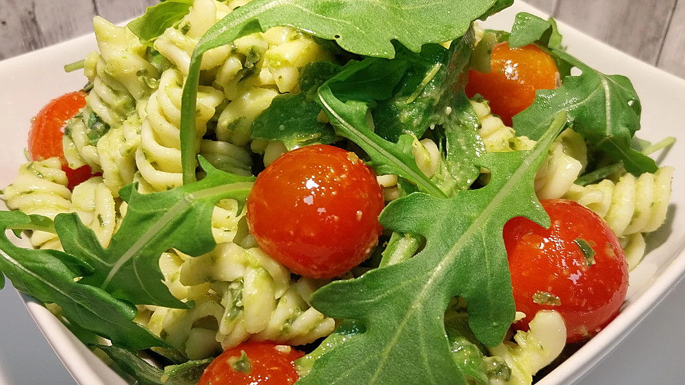 Pastasallad med pesto, körsbärstomater och ruccola.