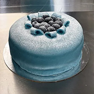 Härlig tårta med sockerkaksbotten, blåbär, vaniljkräm, blåbärsgrädde och marsipan.