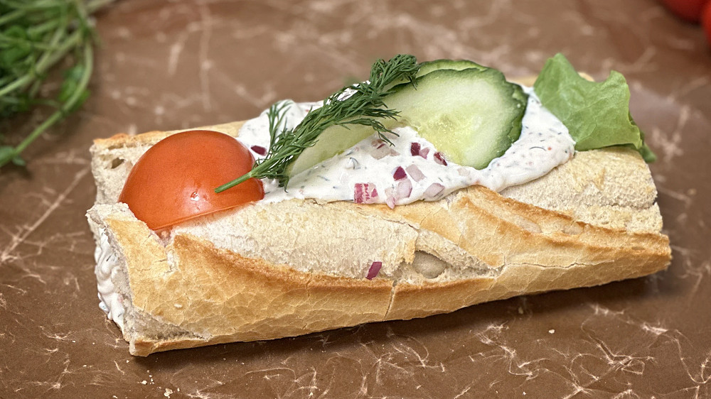 Skagenbaguette fylld med härlagad skagenröra och garnerad med gurka och tomat