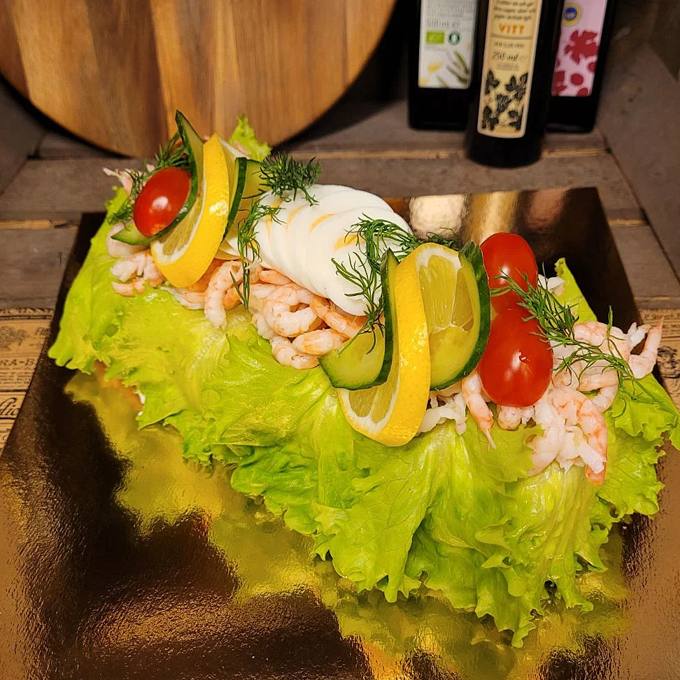 Räksmörgåstårta fylld med vår egengjorda räkröra, toppad med handskalade räkor, ägg och lite annat gott.