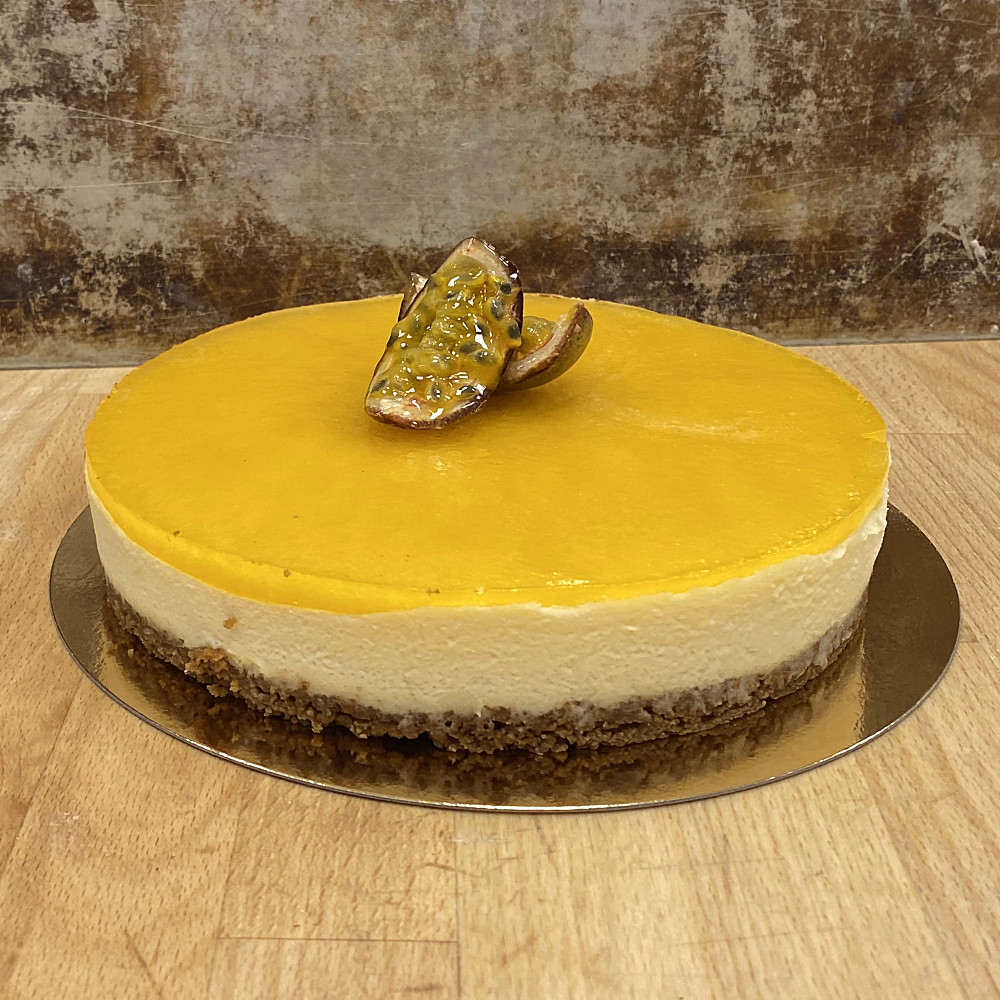 Cheesecake med passionsgelé, dekorerad med klyftad passionsfrukt.
