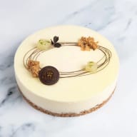 Cheesecake med vit choklad, dekorerad med chokladspiraler och krispiga toppar.