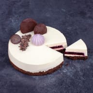 Lyxig tårta med vit mousse, chokladdekorationer och lila maräng.