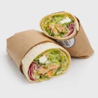 Två halvor av en wrap fylld med lax, sallad, grönsaker och ost, insvept i papper.
