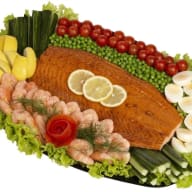 stort serveringsfat med varmrökt lax dekorerat med grönsaker, dill och ägg