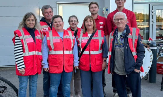 En grupp personer står utomhus framför en byggnad.