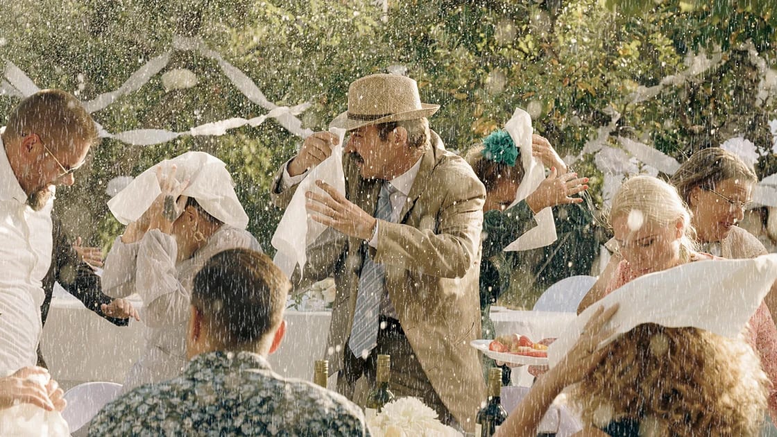 Bild från filmen Regnmannen, människor runt ett festbord.