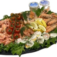 Uppläggningsfat med räkor, havskräftor och lax, serverat med ägghalvor, citronklyftor och såser.