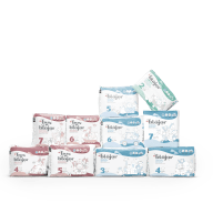 En samling blöjförpackningar står på en vit yta.