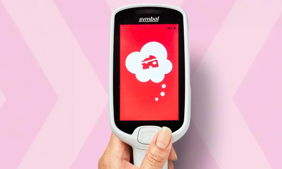 En hand som håller i en självscannare mot rosa bakgrund.