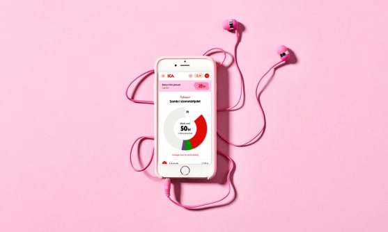 En mobiltelefon med stammishjulet på skärmen och rosa hörlurar ikopplade.