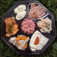 Jultallrik med kall julmat så som julskinka, rödbetssallad, ägg och sill.