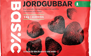 En förpackning med jordgubbar ligger på ett underlag.