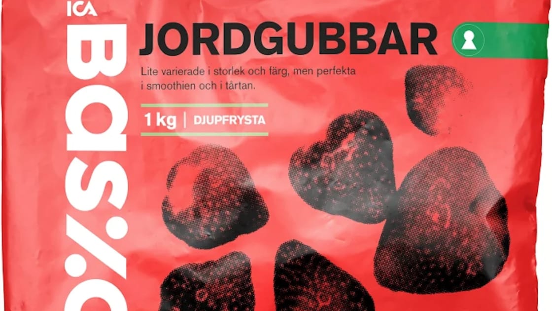 En förpackning med jordgubbar ligger på ett underlag.