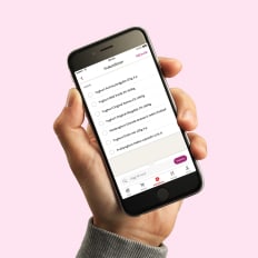 En hand som håller en mobiltelefon med ICA-appen.