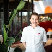 ICAs matkreatör Sophie Berlin står och ler in mot kameran. Hon har kockkläder på sig.